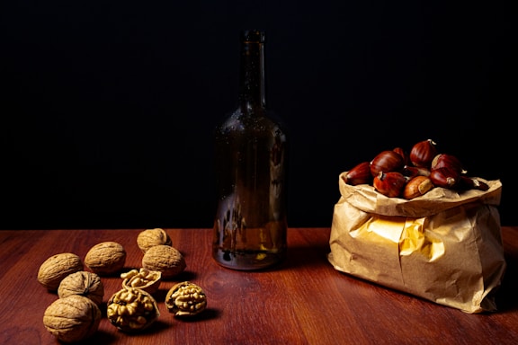a bag full of nuts next to a bottle of wine