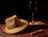 A close-up of a stylish Sebastian 68 hat resting on a wooden table with soft party lights in the background.
