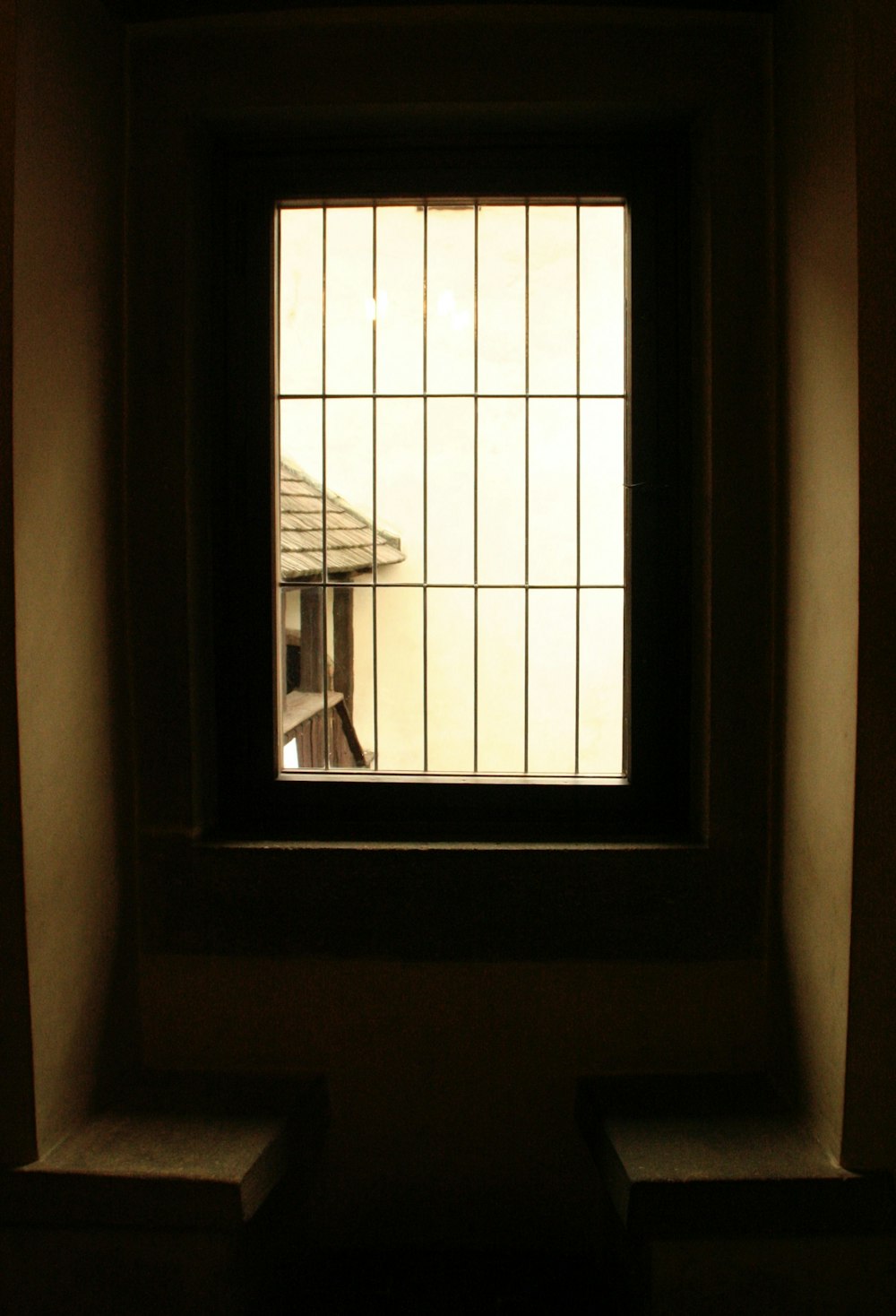a window in a wall with a view of a house