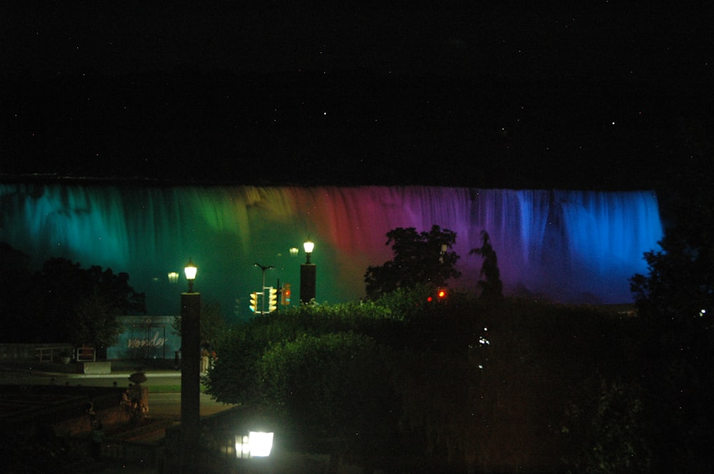 Ein regenbogenfarbener Wasserfall, der nachts beleuchtet wird