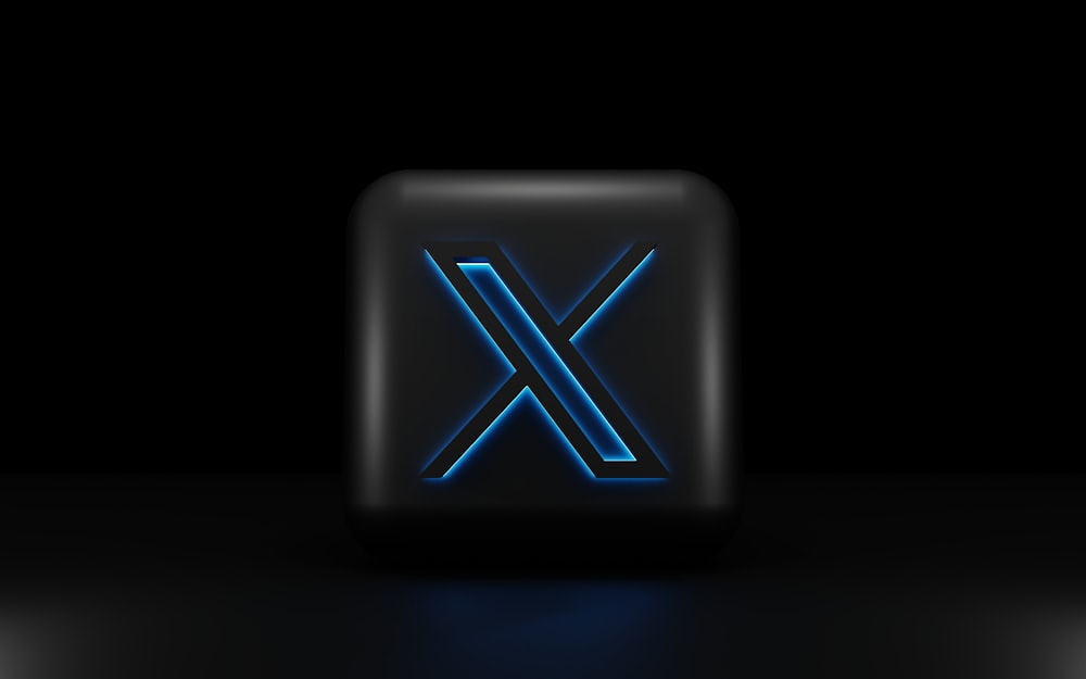 a blue illuminated letter x on a black background