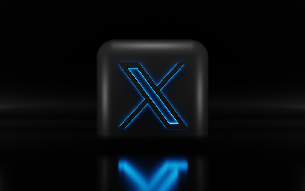 a blue illuminated letter x on a black background