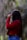 a woman in a red jacket is holding an umbrella