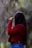 a woman in a red jacket is holding an umbrella