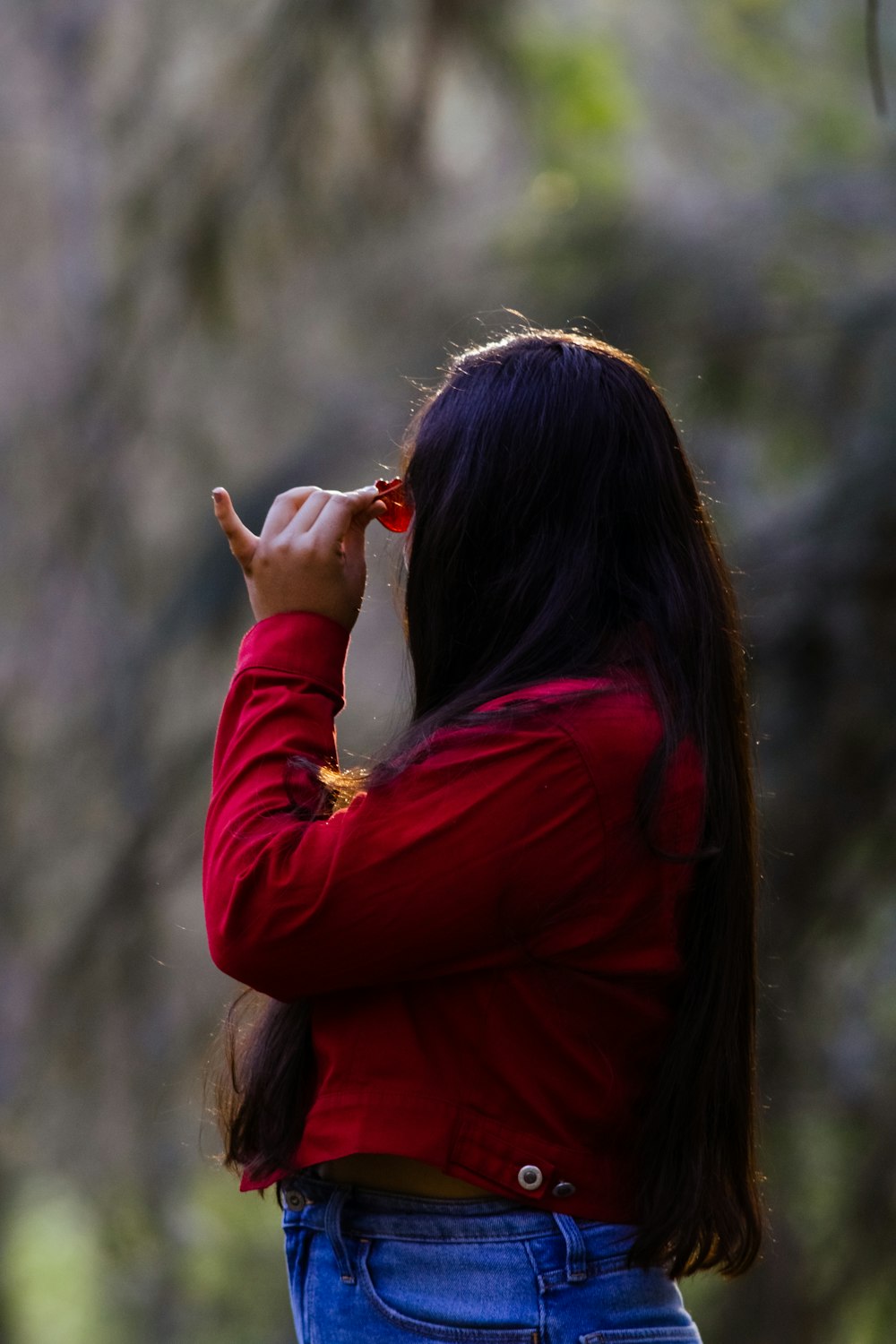 a woman in a red jacket is holding an umbrella