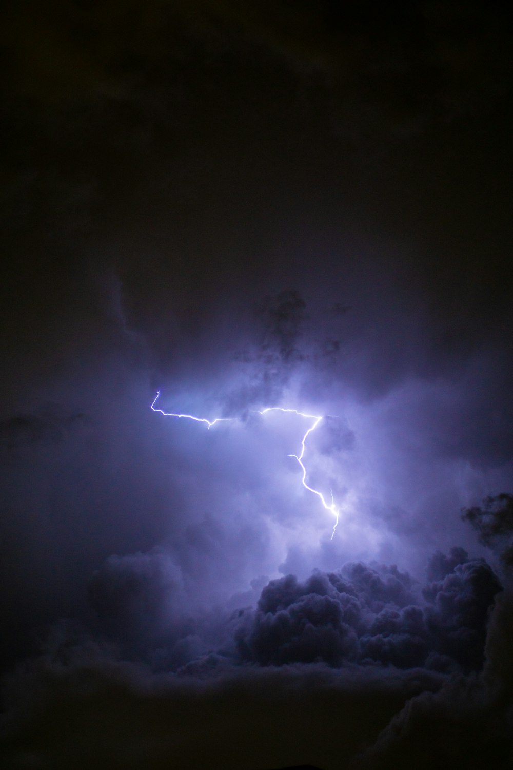 a lightning bolt hitting through a cloudy sky