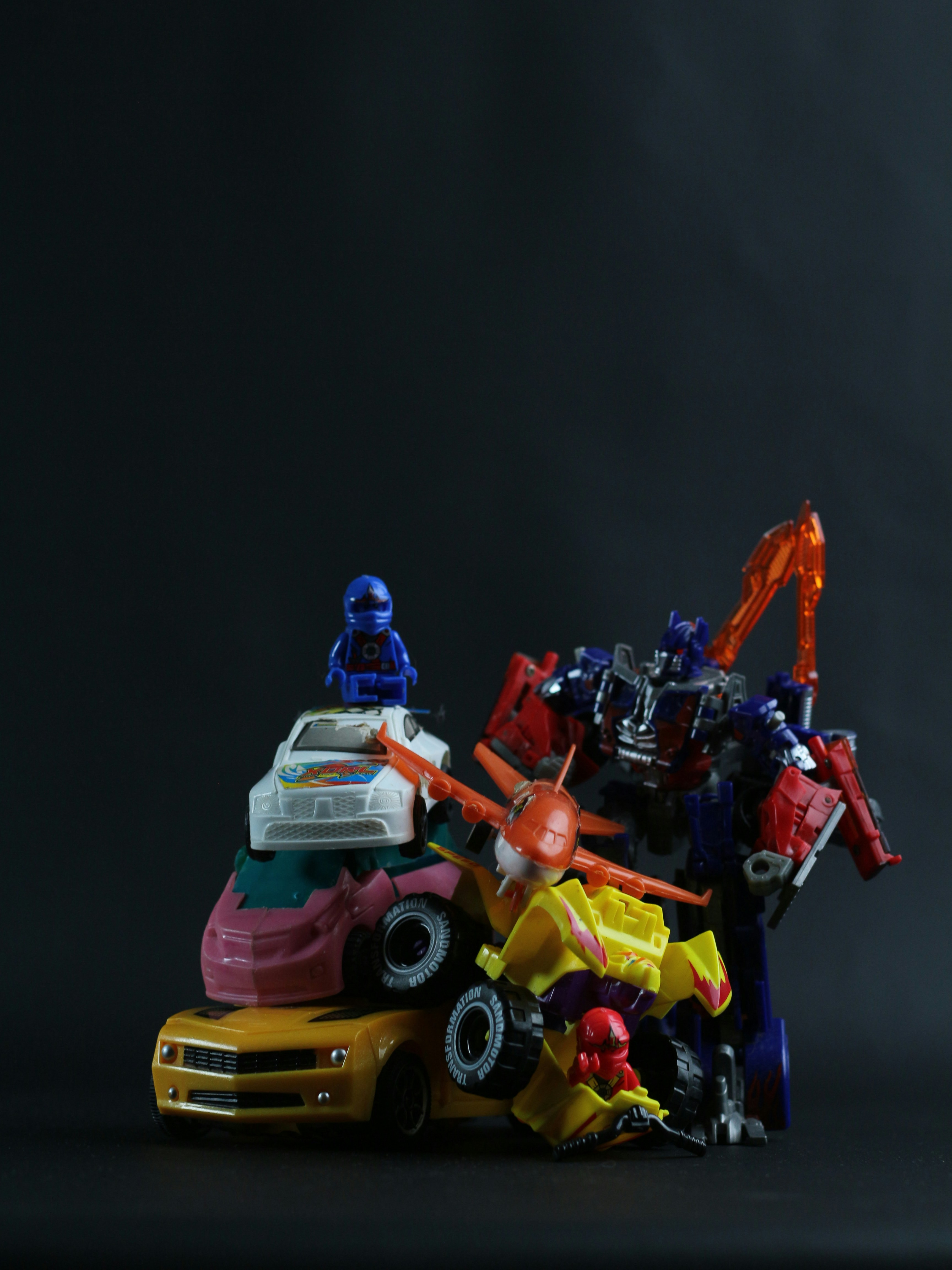 Colorful toys and kids products on dark moody background with shadowed atmospheric lighting
