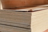 Close-up of smooth plywood sheets stacked neatly in a warehouse.