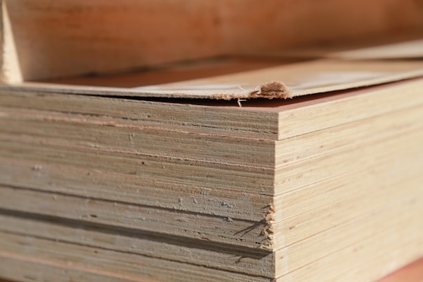 Close-up of freshly cut plywood sheets stacked neatly in a Suffolk workshop.