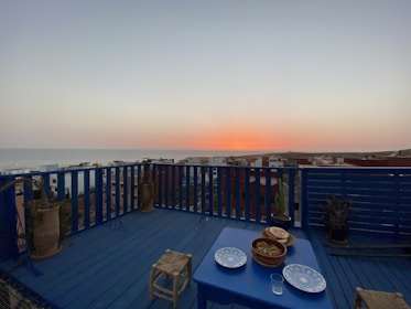 A serene view of a spacious flat balcony overlooking a city skyline at sunset.
