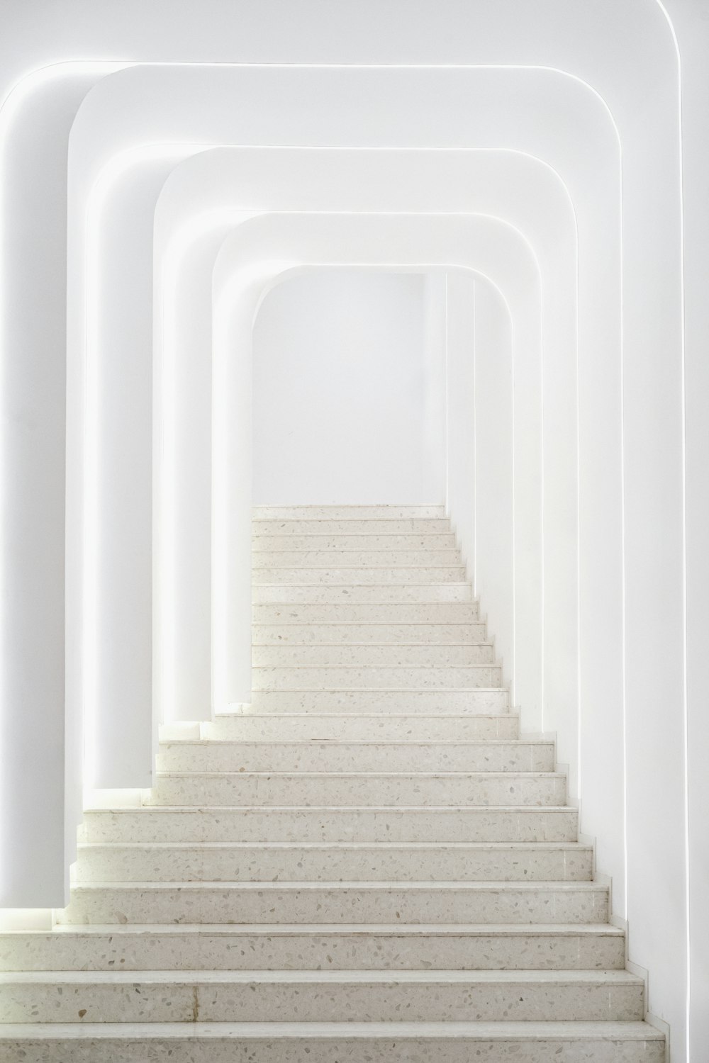 a white staircase leading to a white wall