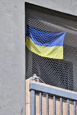 A friendly professional installing a safety net on a modern apartment balcony.