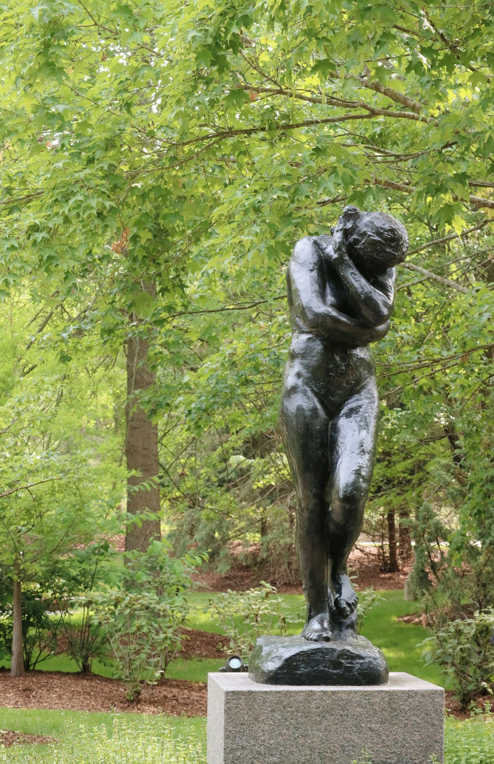 a statue of a woman in the middle of a park