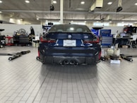A sleek national car parked inside the auto workshop with tools around