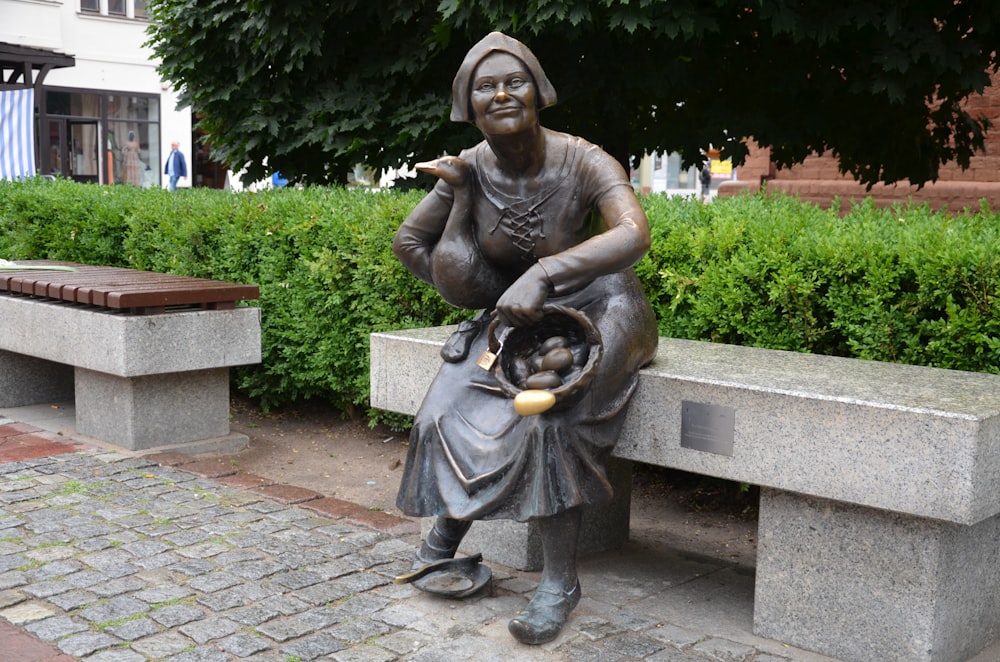 a statue of a woman sitting on a bench