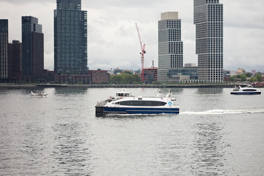 a boat traveling on the water in front of a city