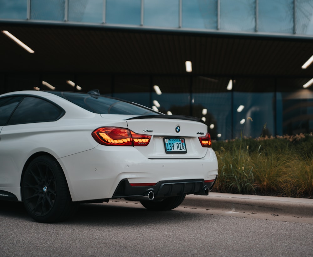 a white car parked in front of a building