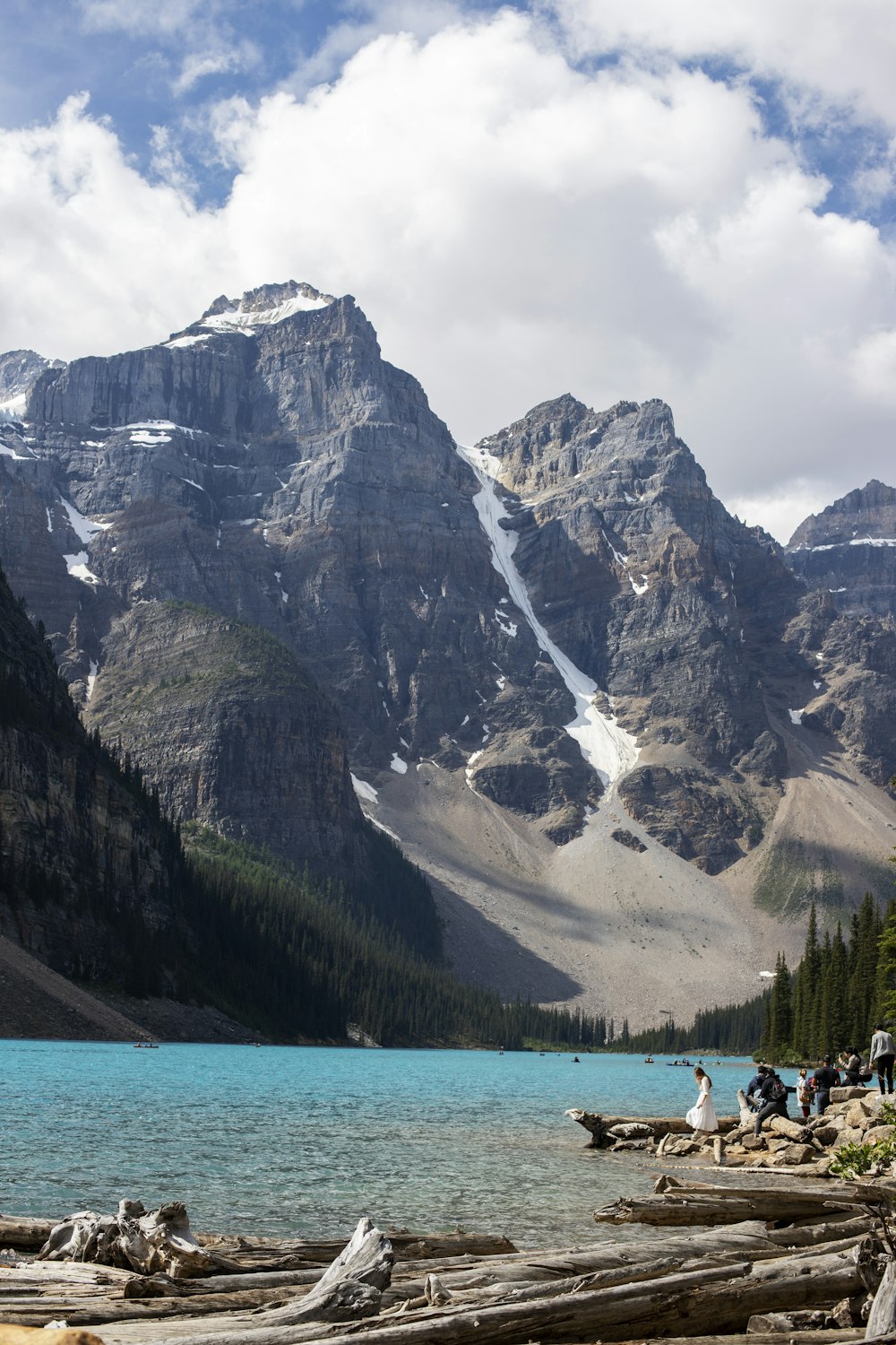 a group of people standing next to a mountain lake