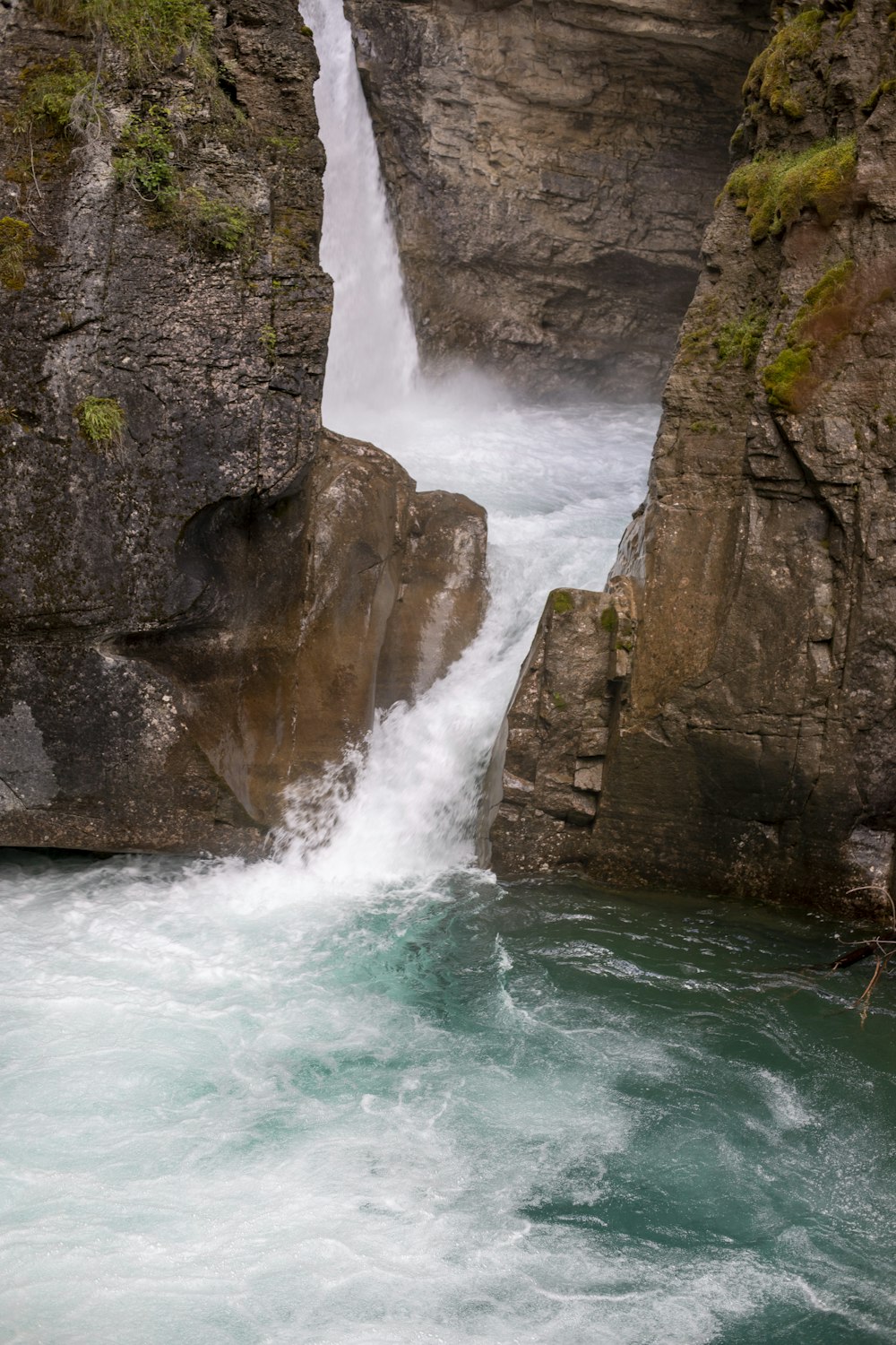 a waterfall is coming out of the side of a cliff