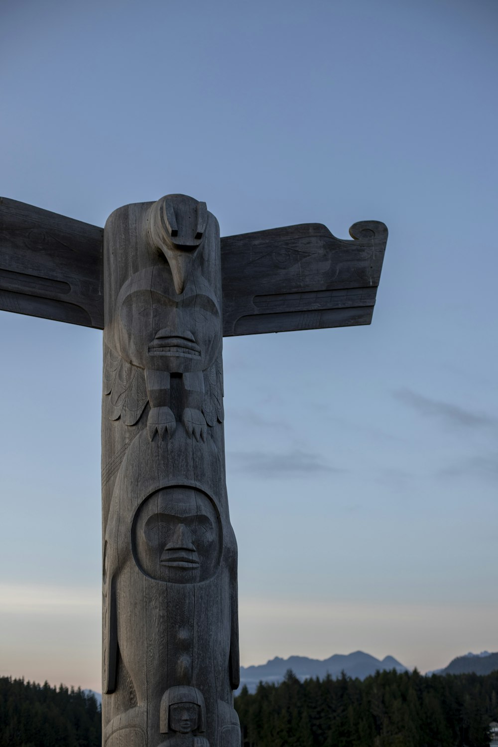 a carved wooden pole with a face on it