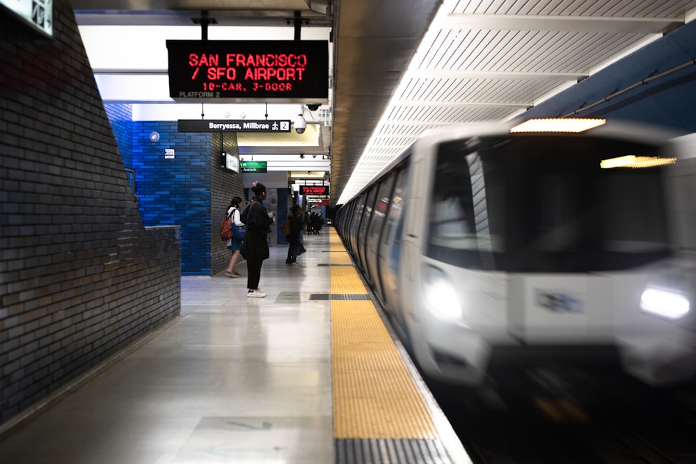 a train traveling through a train station next to a platform