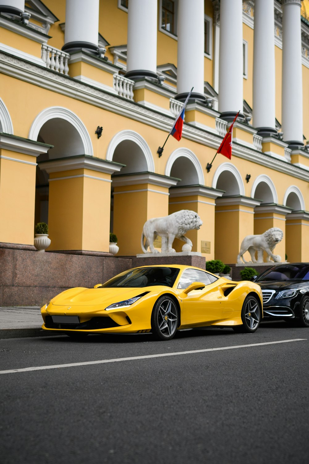 a yellow sports car parked in front of a building