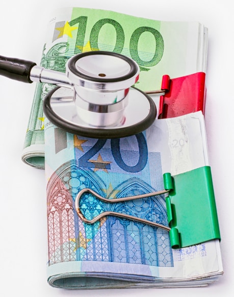 a stethoscope sitting on top of a pile of money