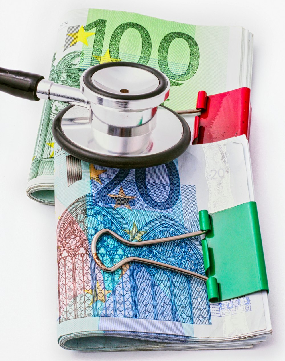 a stethoscope sitting on top of a pile of money
