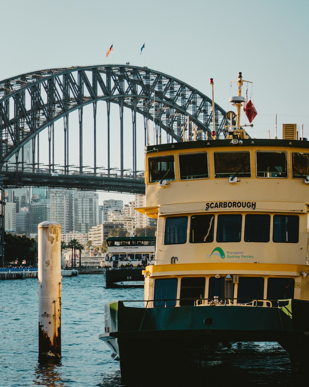 a large yellow boat in the water near a bridge