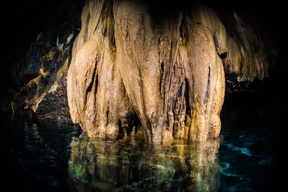 the water is reflecting the rock formations in the cave