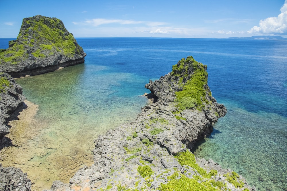 a body of water surrounded by rocks and grass