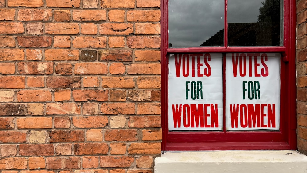 a red brick building with two signs on the window