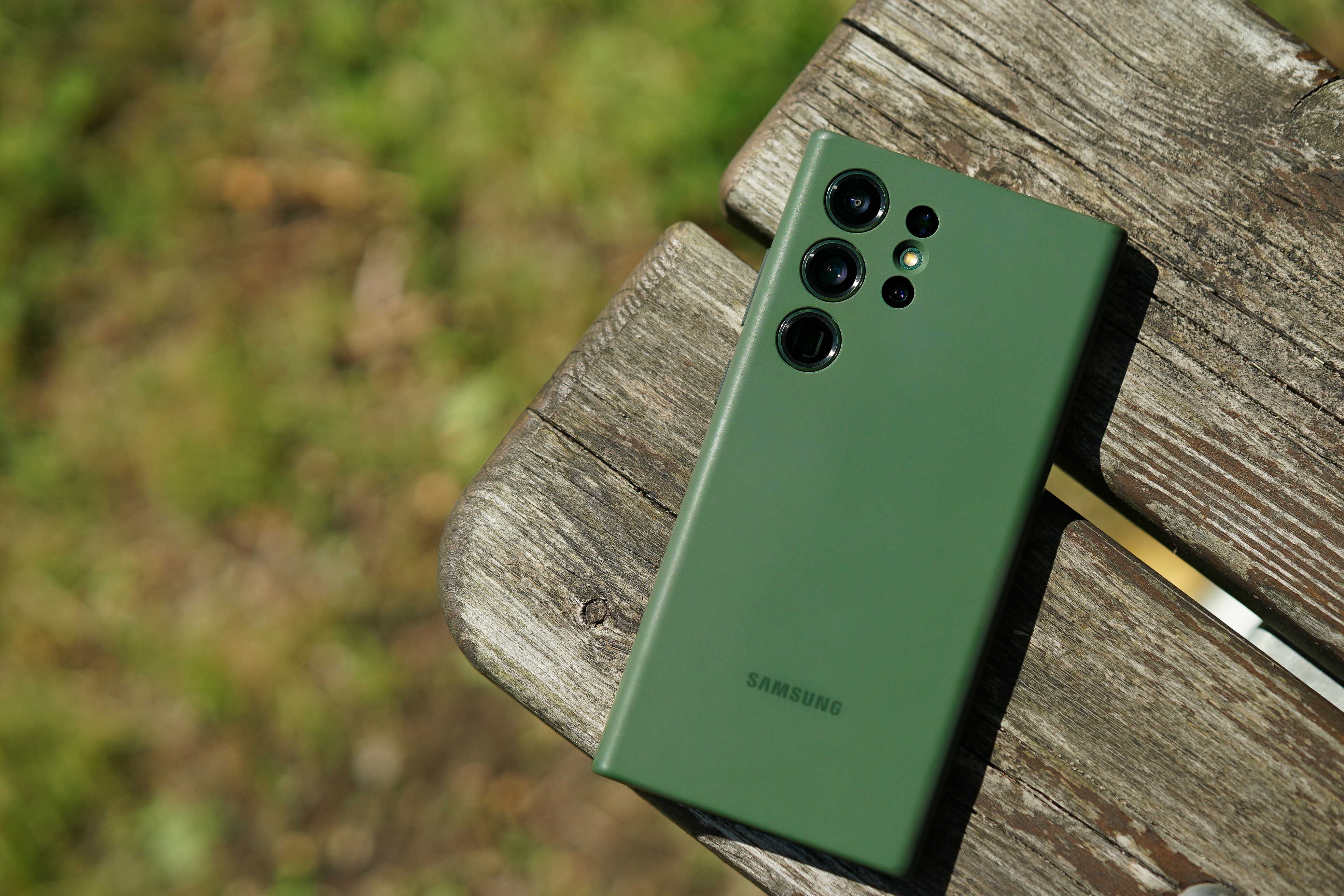 a green cell phone sitting on top of a wooden bench