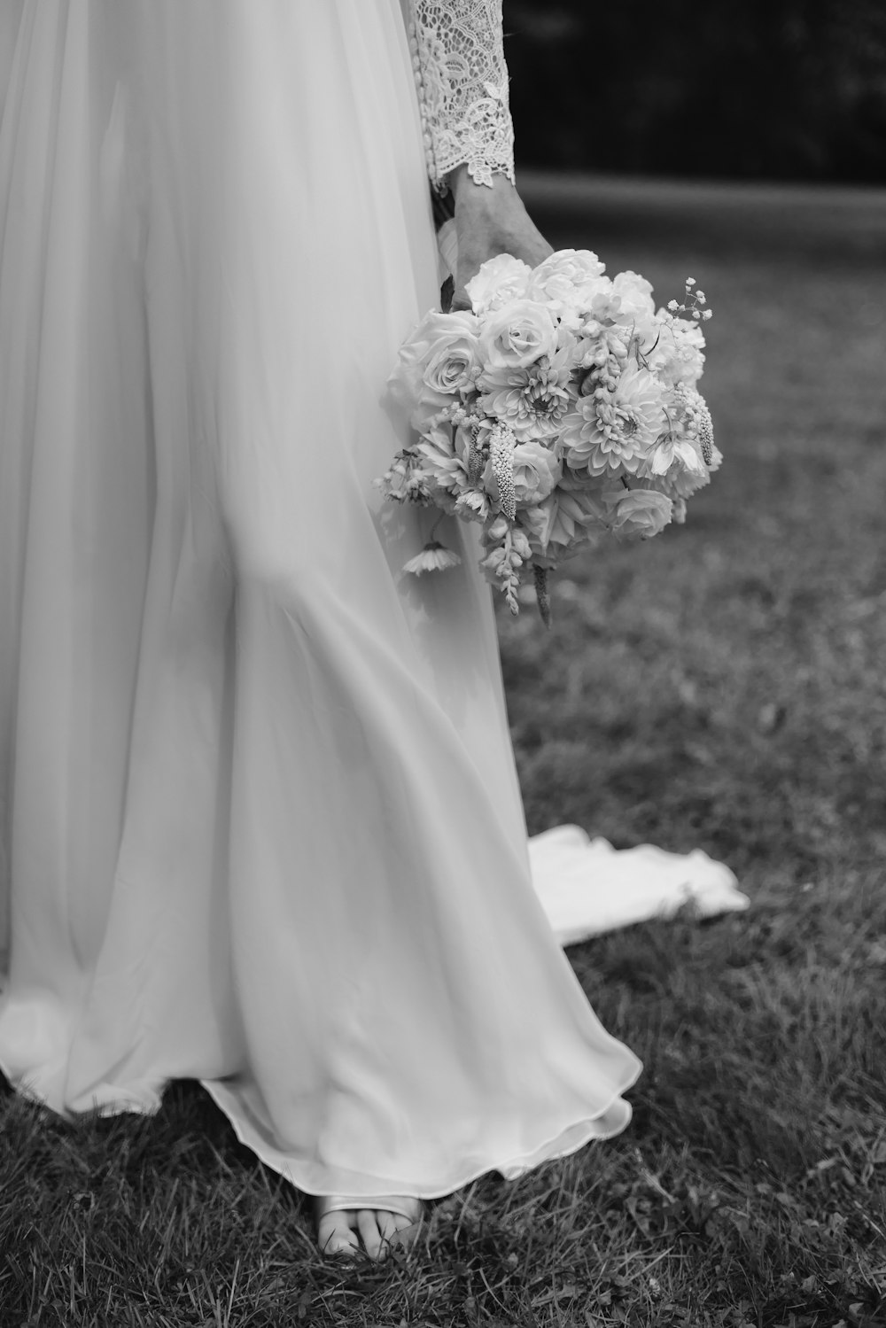 a woman in a wedding dress holding a bouquet of flowers