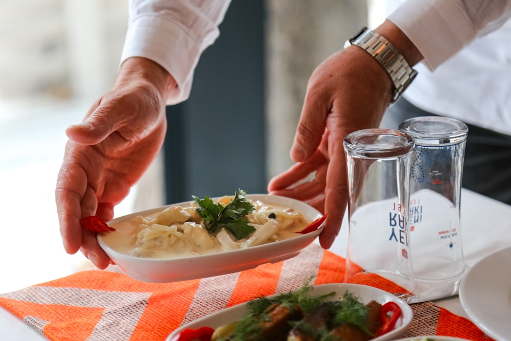 a person holding a bowl of food on a table