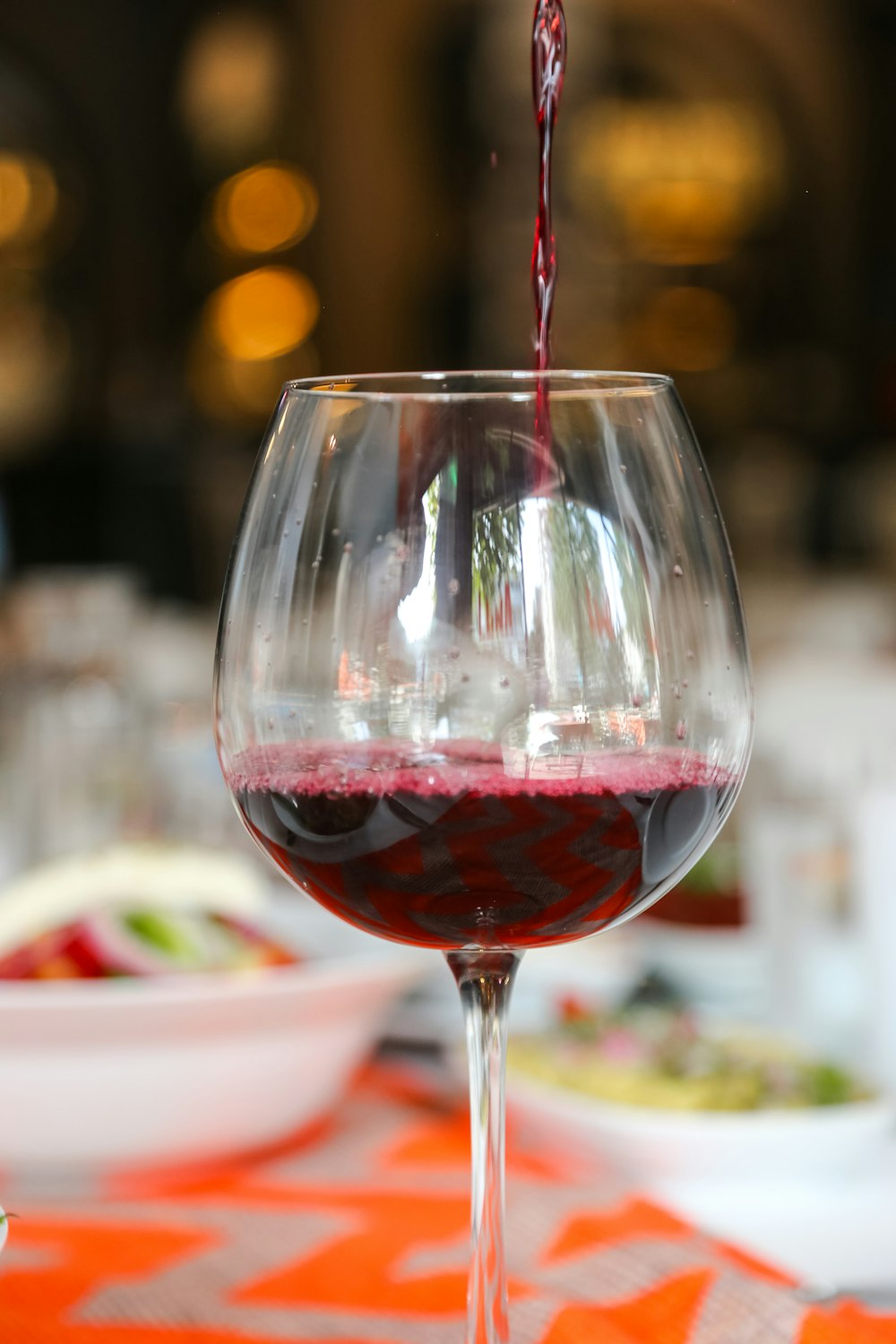a red wine being poured into a wine glass