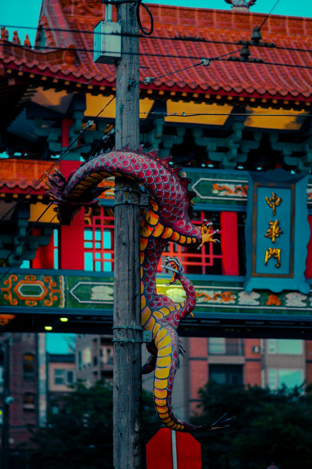 a dragon statue on a pole in front of a building