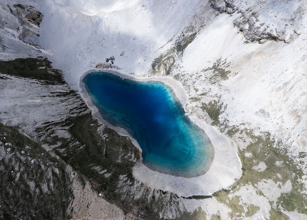 a blue lake surrounded by snow covered mountains