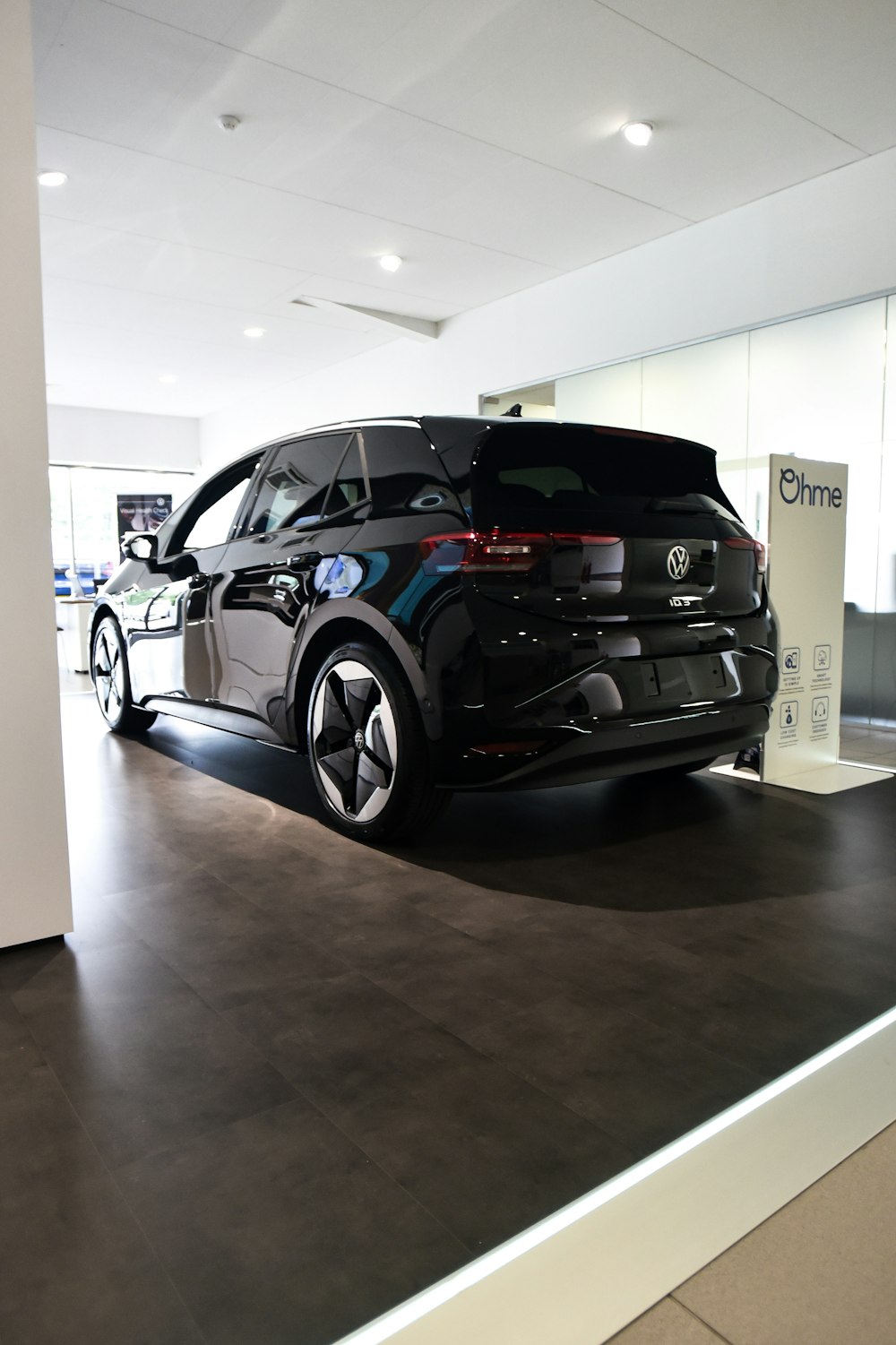 a black car is parked in a showroom