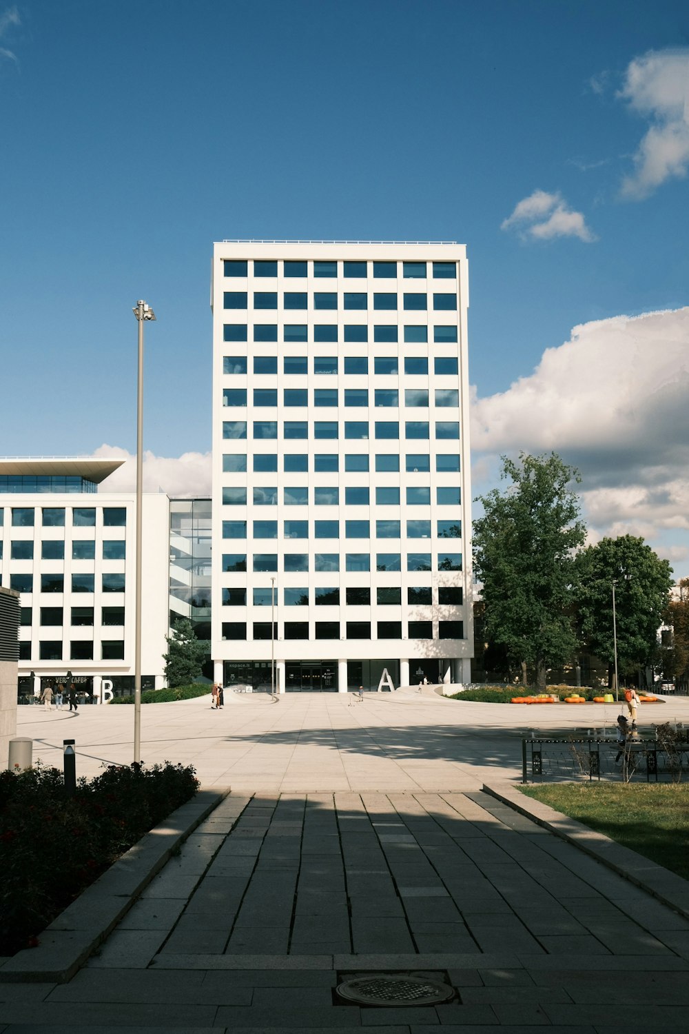 a tall white building sitting next to a lush green park