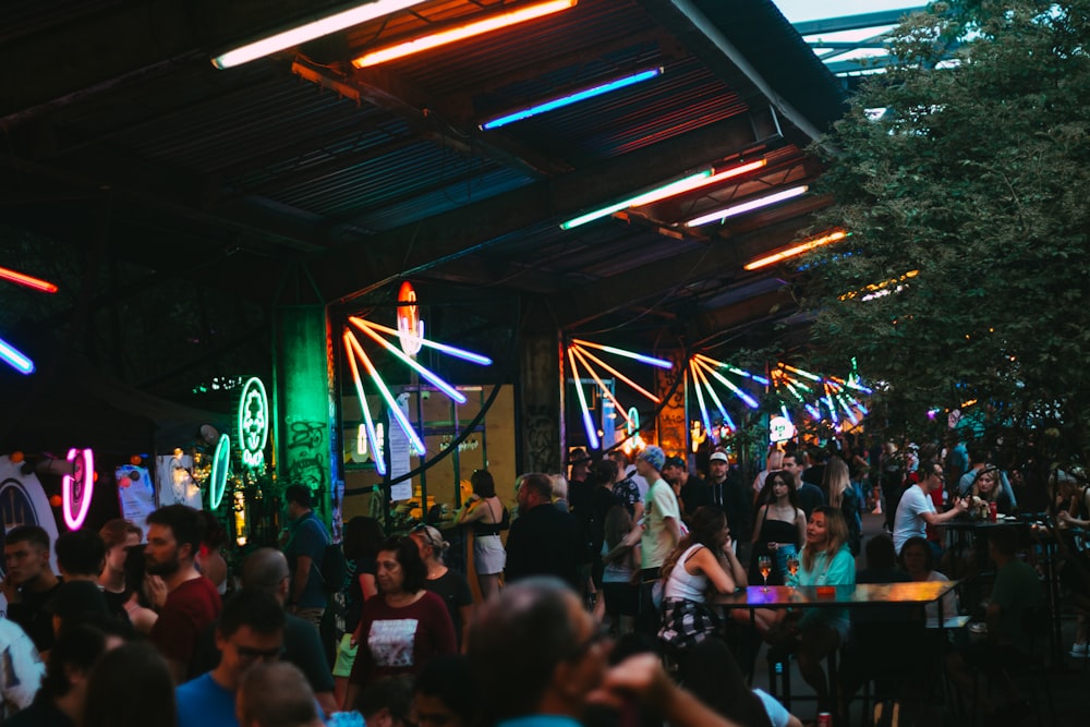 uma multidão de pessoas em pé ao redor de um bar