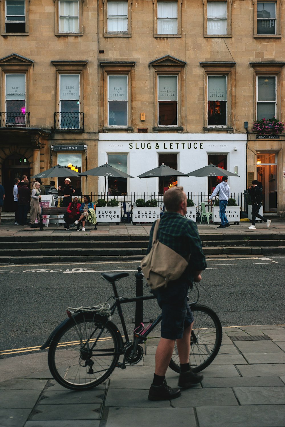 a man standing next to a bike on a sidewalk