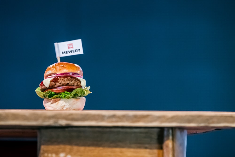 um hambúrguer sentado em cima de uma mesa de madeira