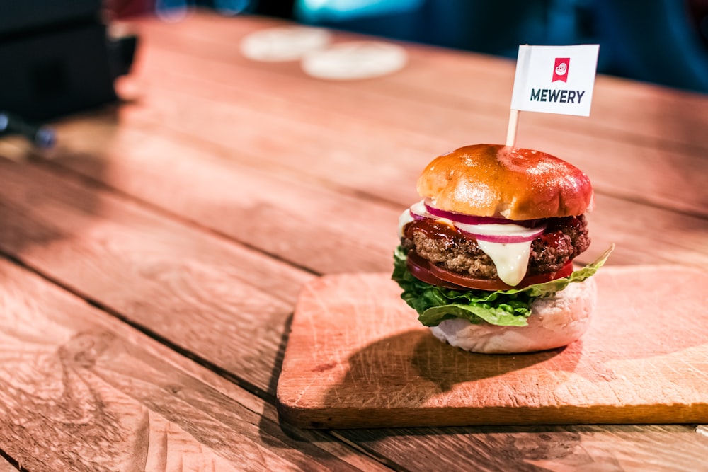 a hamburger sitting on top of a wooden cutting board