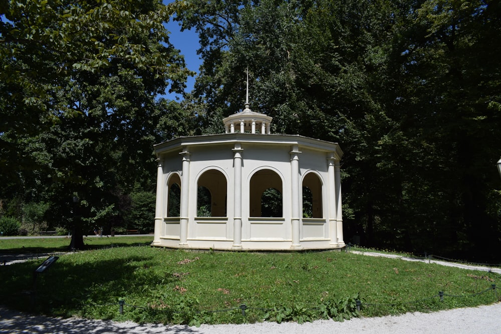 Un gazebo bianco seduto nel mezzo di un parco