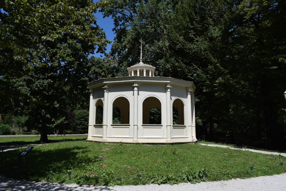 a white gazebo sitting in the middle of a park