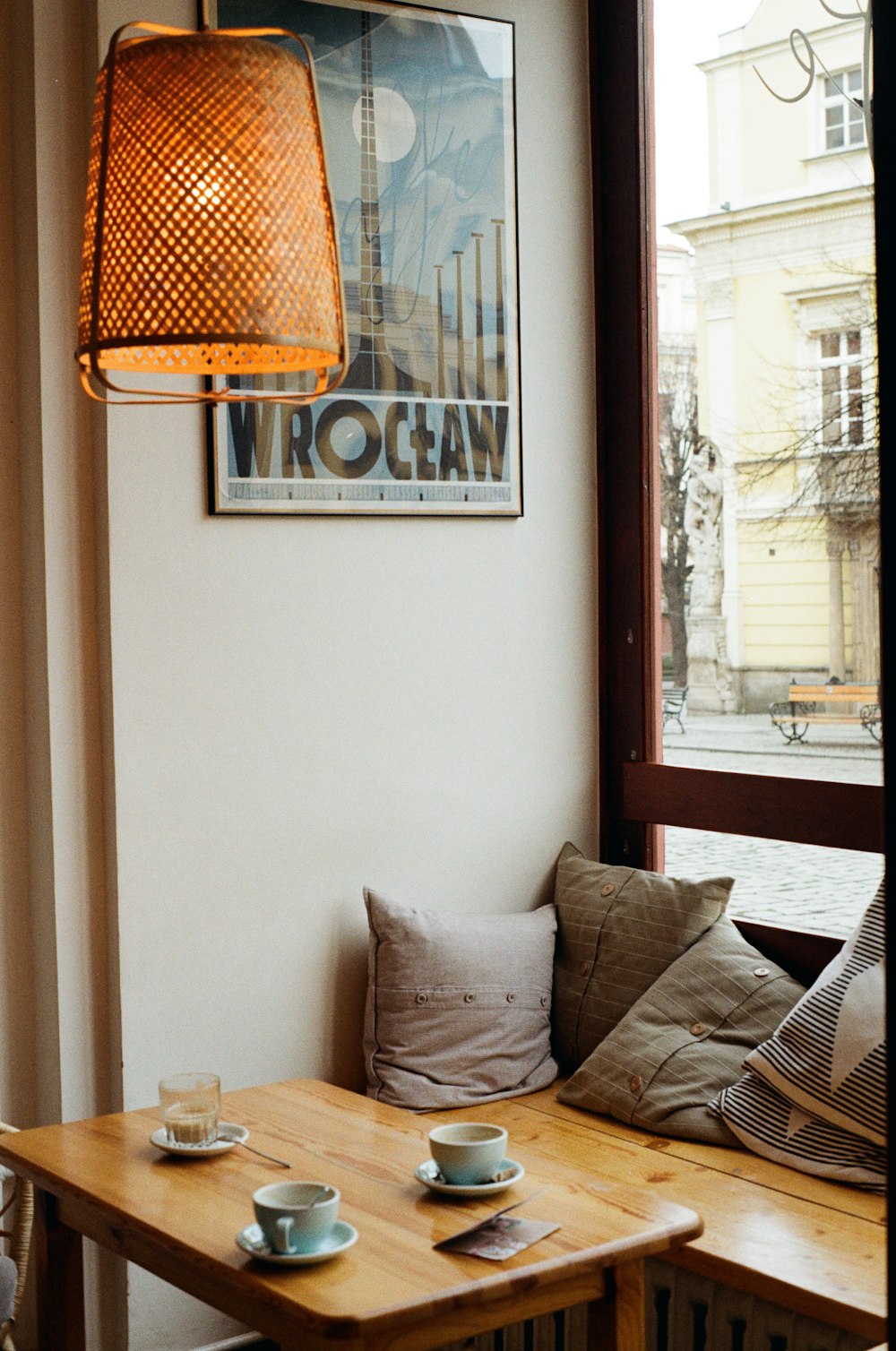 a wooden table with two cups and saucers on it