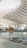 The spacious interior showcases a modern architectural design with sweeping, curved lines and a large, lattice-patterned skylight allowing natural light to flood the space. In the center, there is a striking sculpture surrounded by greenery, which adds a touch of nature to the sleek, contemporary setting. Signs with directional information are visible on the polished floor.