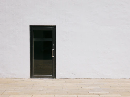 A minimalist silver door featuring circuit-board patterns illuminated softly.