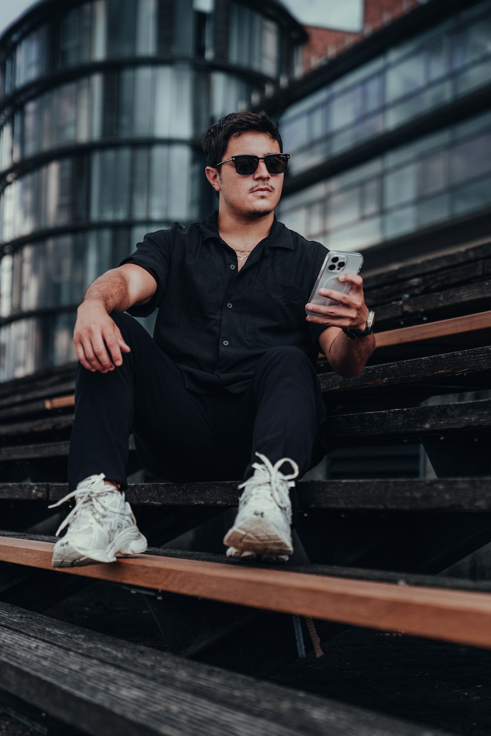 a man sitting on some steps holding a cell phone